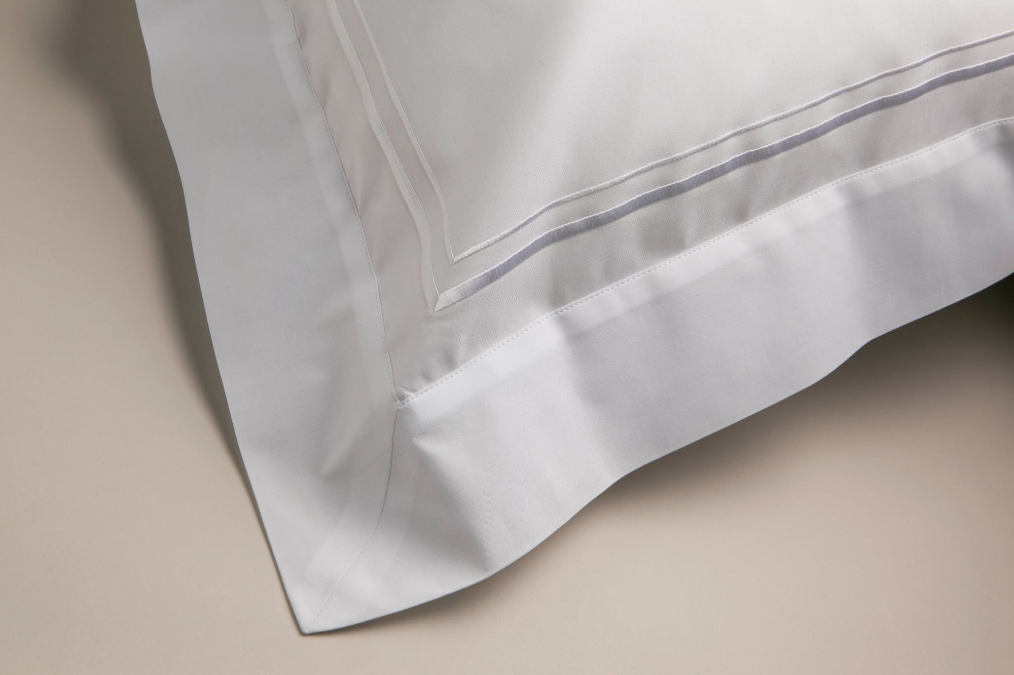 View from an angle of a Savoir  Oxford pillowcase with white corded details