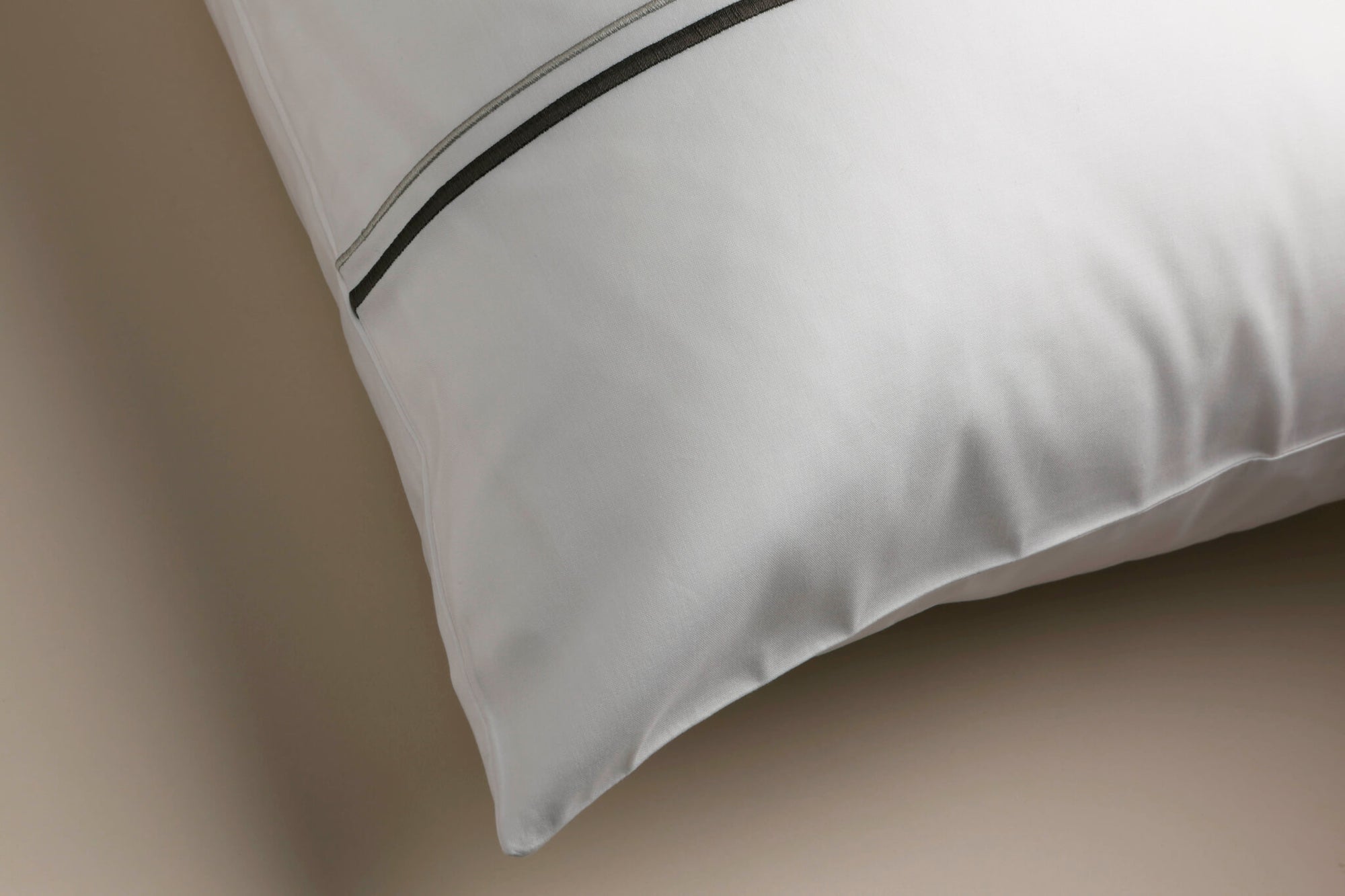 Corner of a pillow case with grey cording