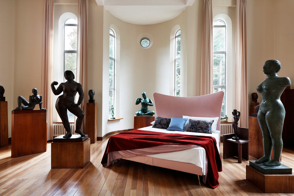 Savoir Amelia bed in a room with sculptures