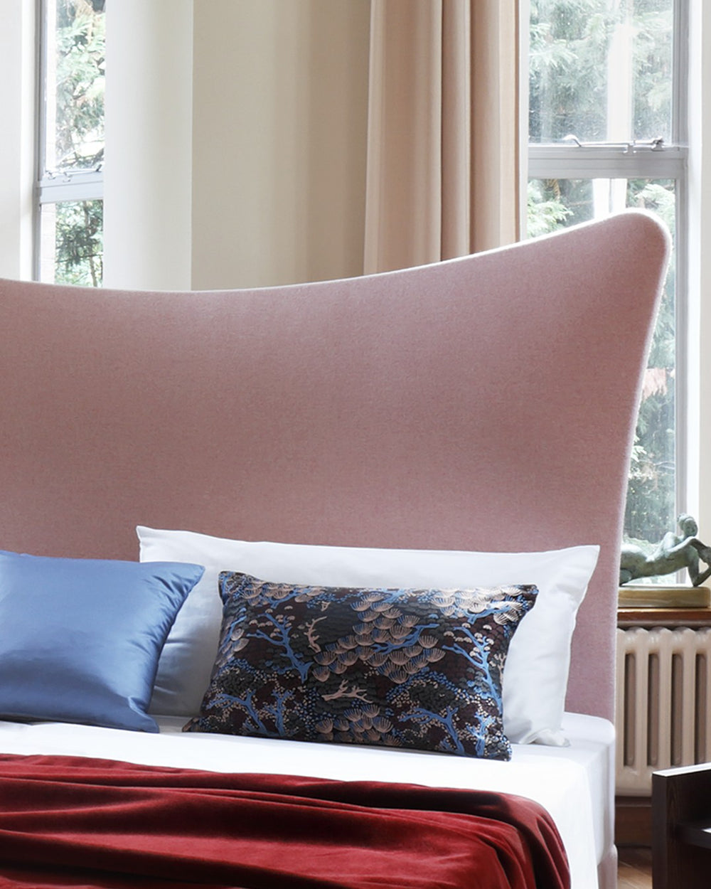 Close-up of the Savoir Amelia bed with a light pink headboard