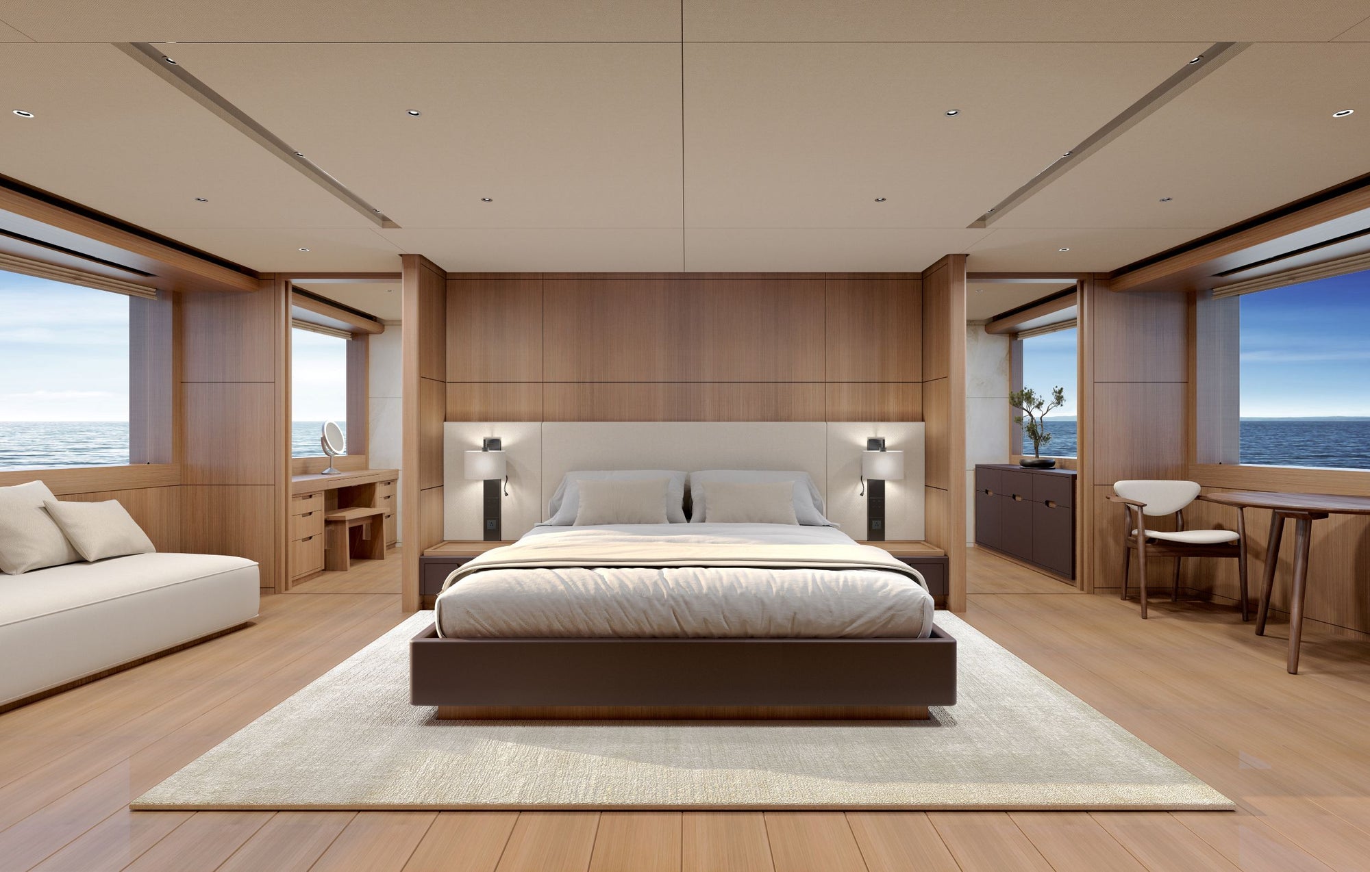 A luxury yacht master bedroom featuring a low-profile platform bed with white bedding, a light beige rug, warm wood paneling, and large windows overlooking the ocean.