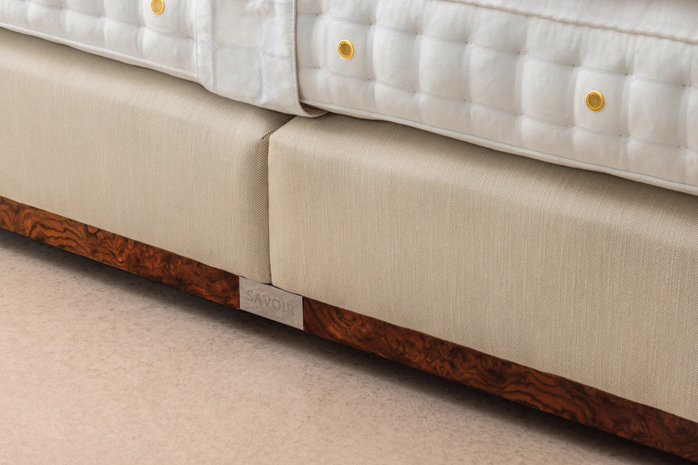 Close-up of the Luna base with cream upholstered side panels and walnut wood base