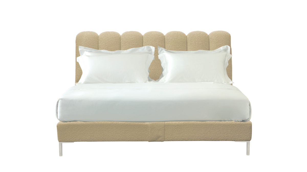 A modern upholstered bed frame with a scalloped headboard and matching base, shown with white bedding and two white pillows on a plain white background.