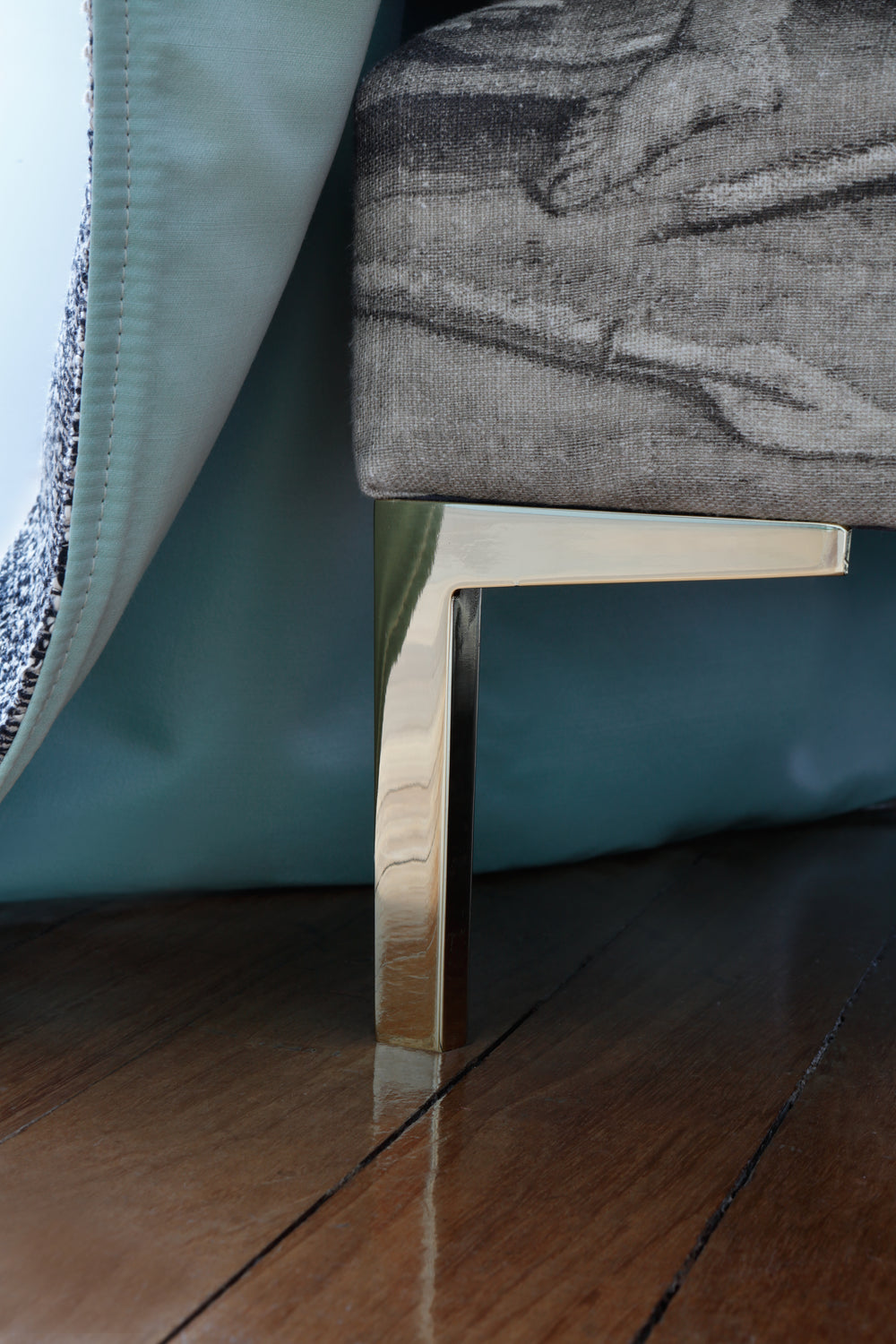 Close-up of our Savoir Felix bed and one metal leg with a brass finish.