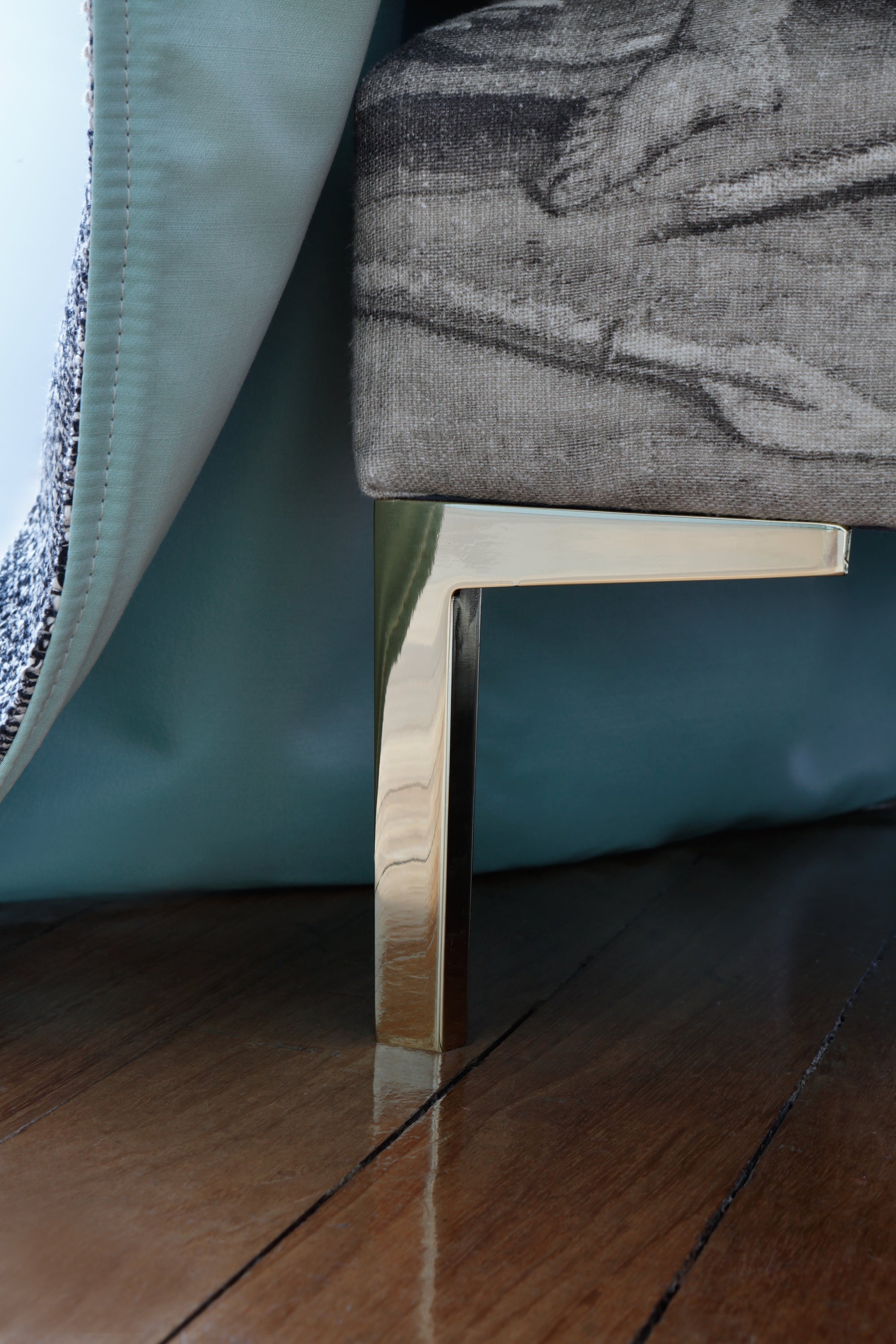 Close-up of our Savoir Felix bed and one metal leg with a brass finish.