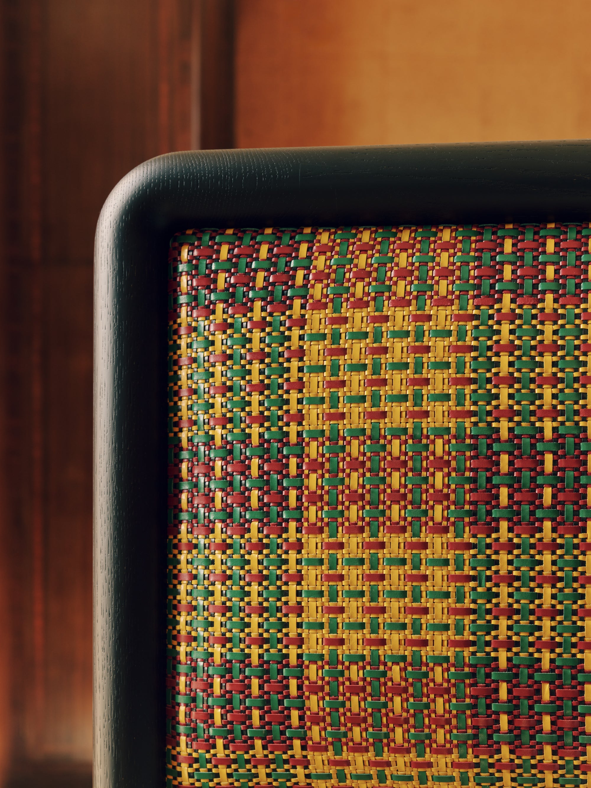 Close-up of a headboard with a colorful woven pattern on a wooden background