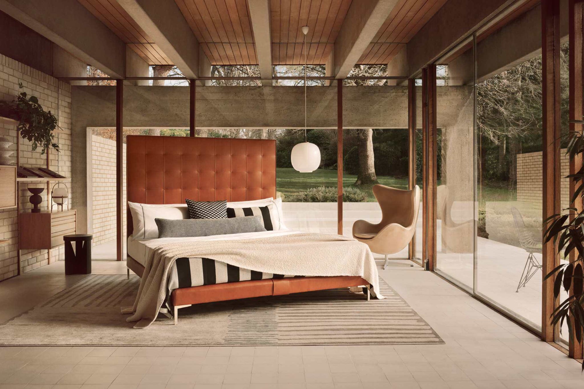 Modern bedroom with the Winston bed, leather headboard, and sliding glass doors.