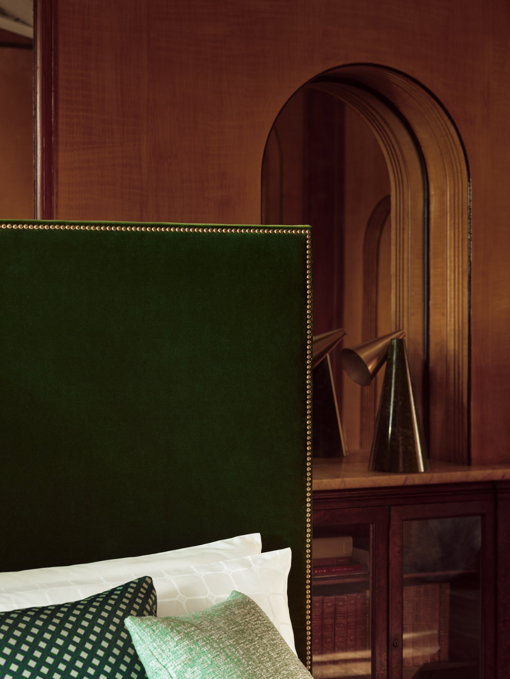 Close-up view of the Harlech bed with a green headboard