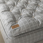 Gray mattress and topper with trellis fabric and brand label