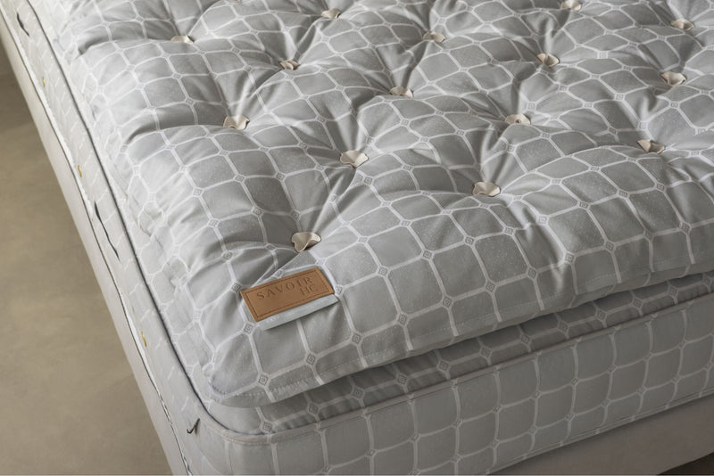 Gray mattress and topper with trellis fabric and brand label