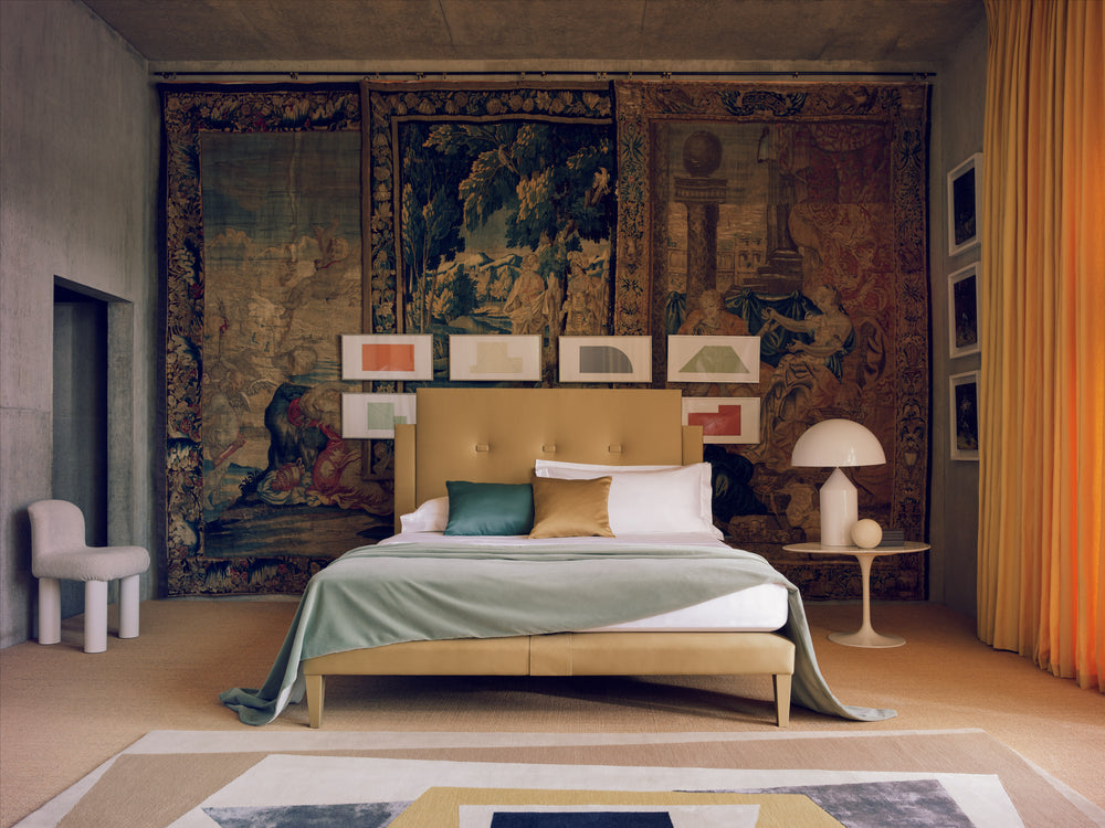 The Savoy bed in gold in a post-modern room with tapestries on the walls