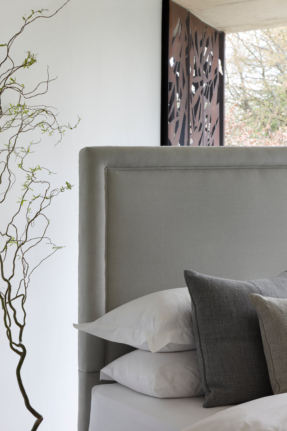 Close-up of the Savoir No4 Reformer headboard upholstered in linen.