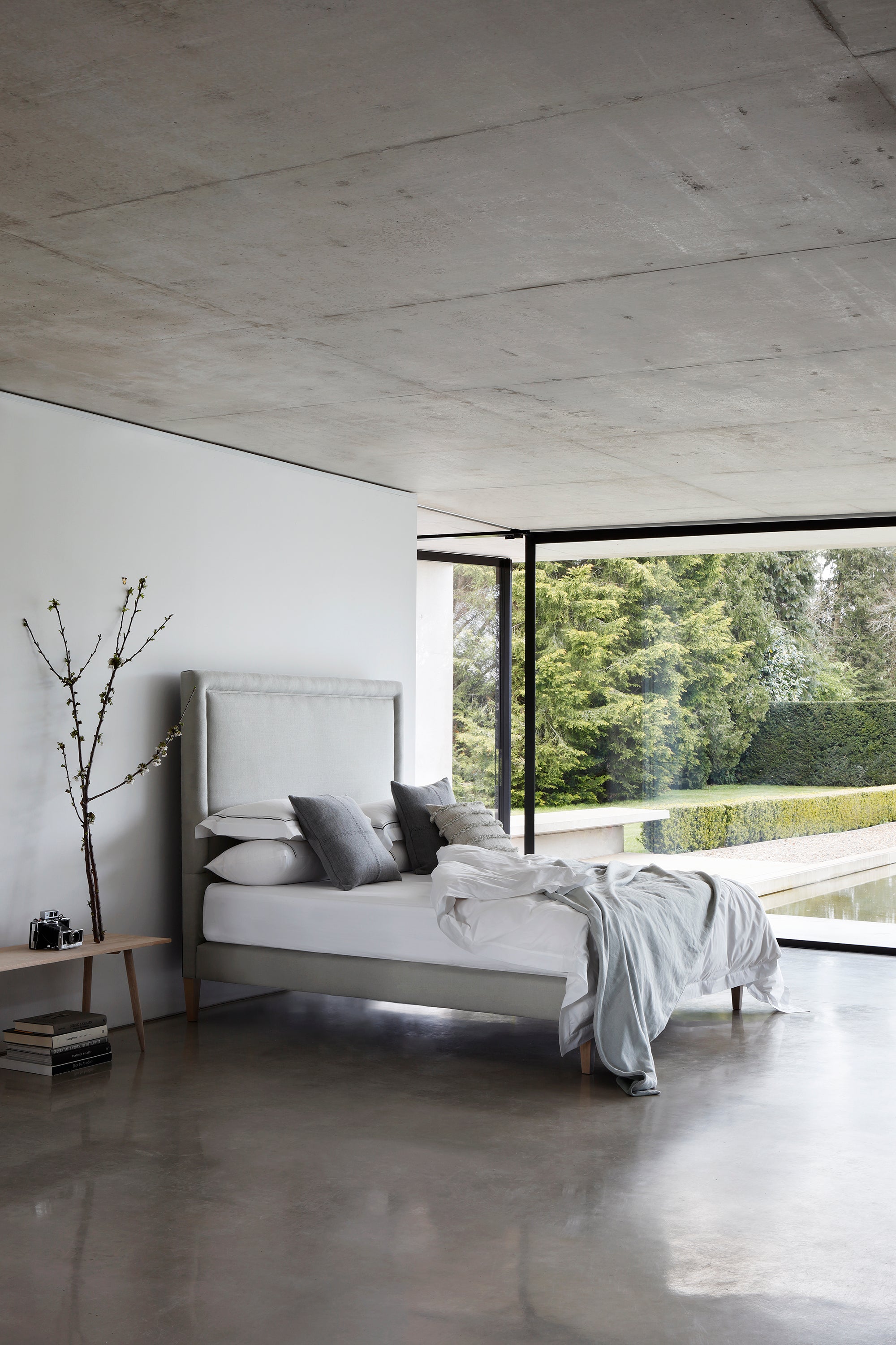 Side view of the Savoir No4 Reformer bed with headboard and base upholstered in linen.