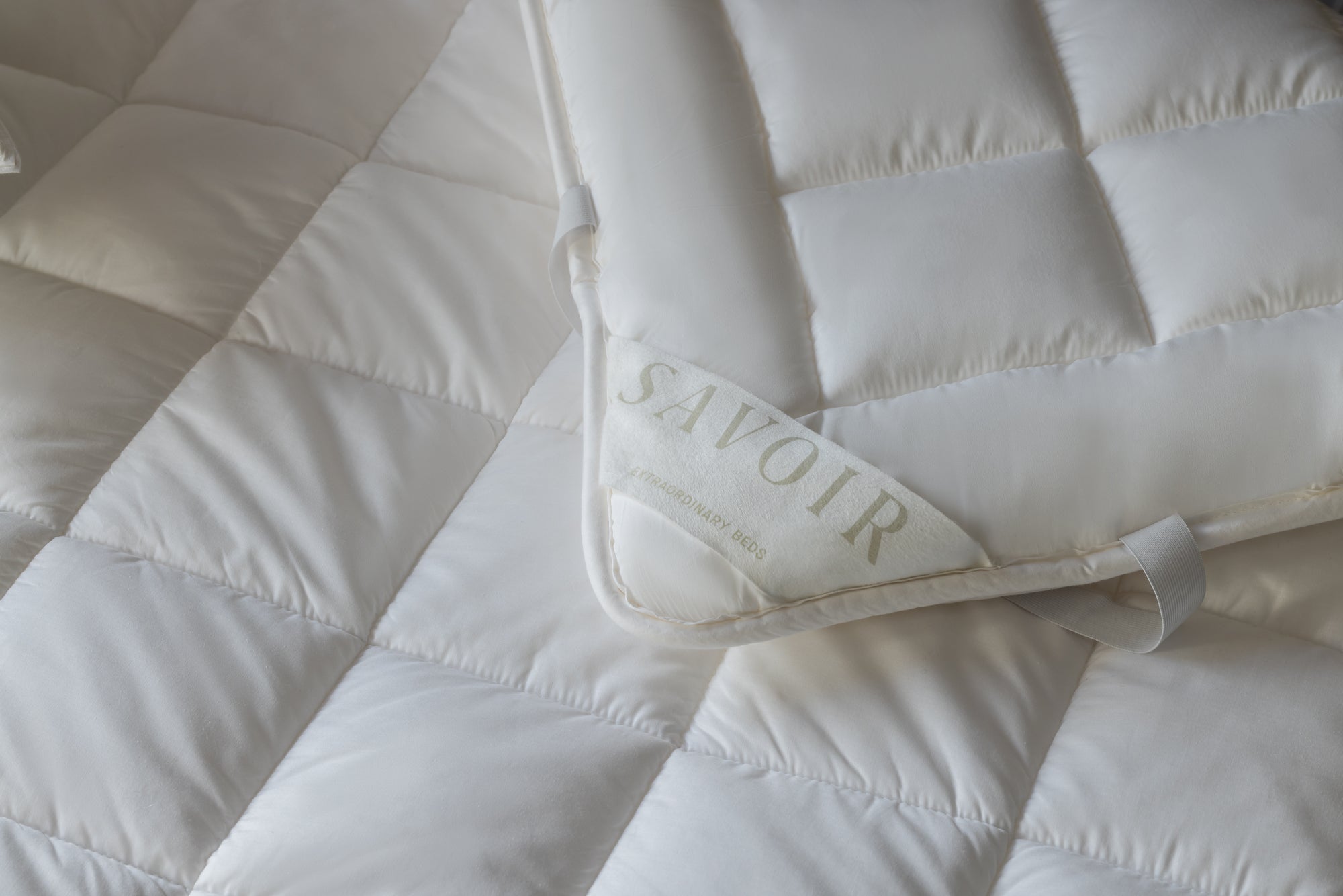 Savoir label sewn into the corner of tencel and maize mattress protector