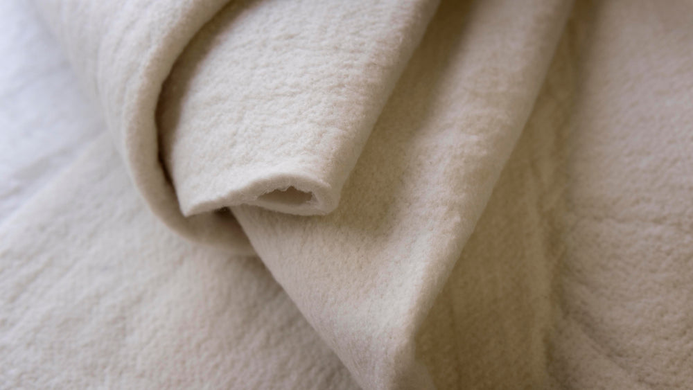 Close-up of folded wool fabric in creamy ivory