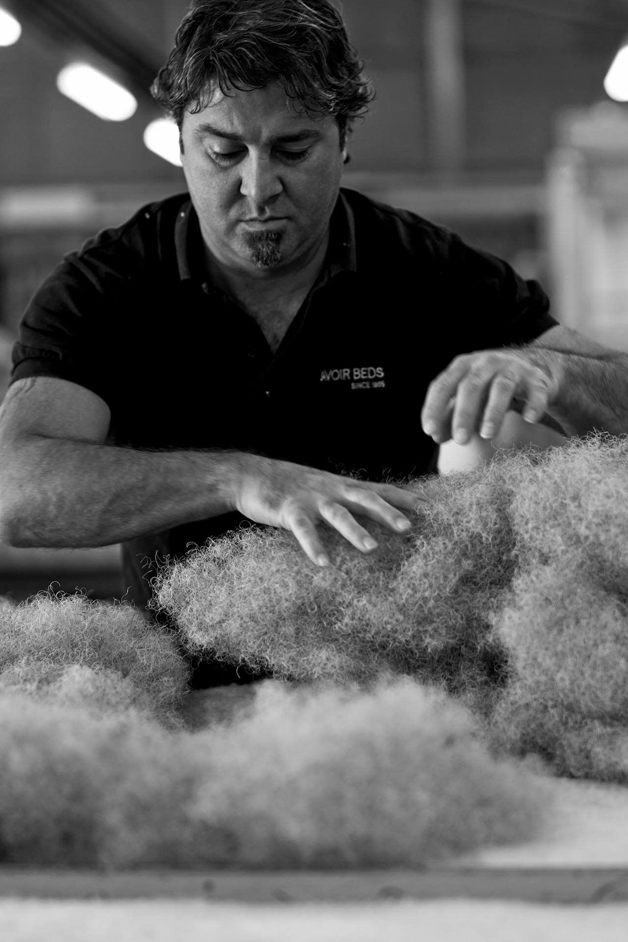 A Savoir craftsman laying out loose hair in a mattress