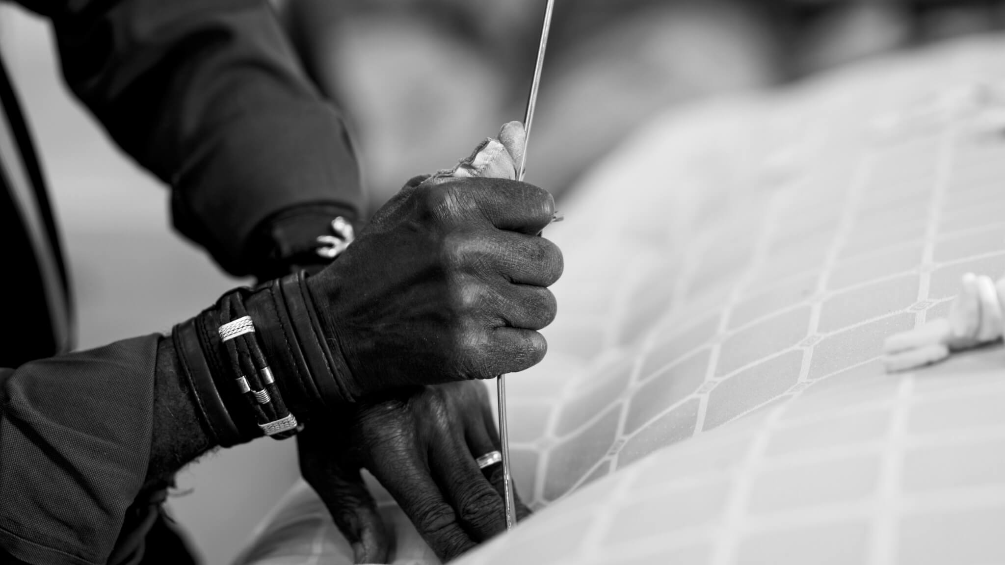 Craftsman hand tufting a mattress