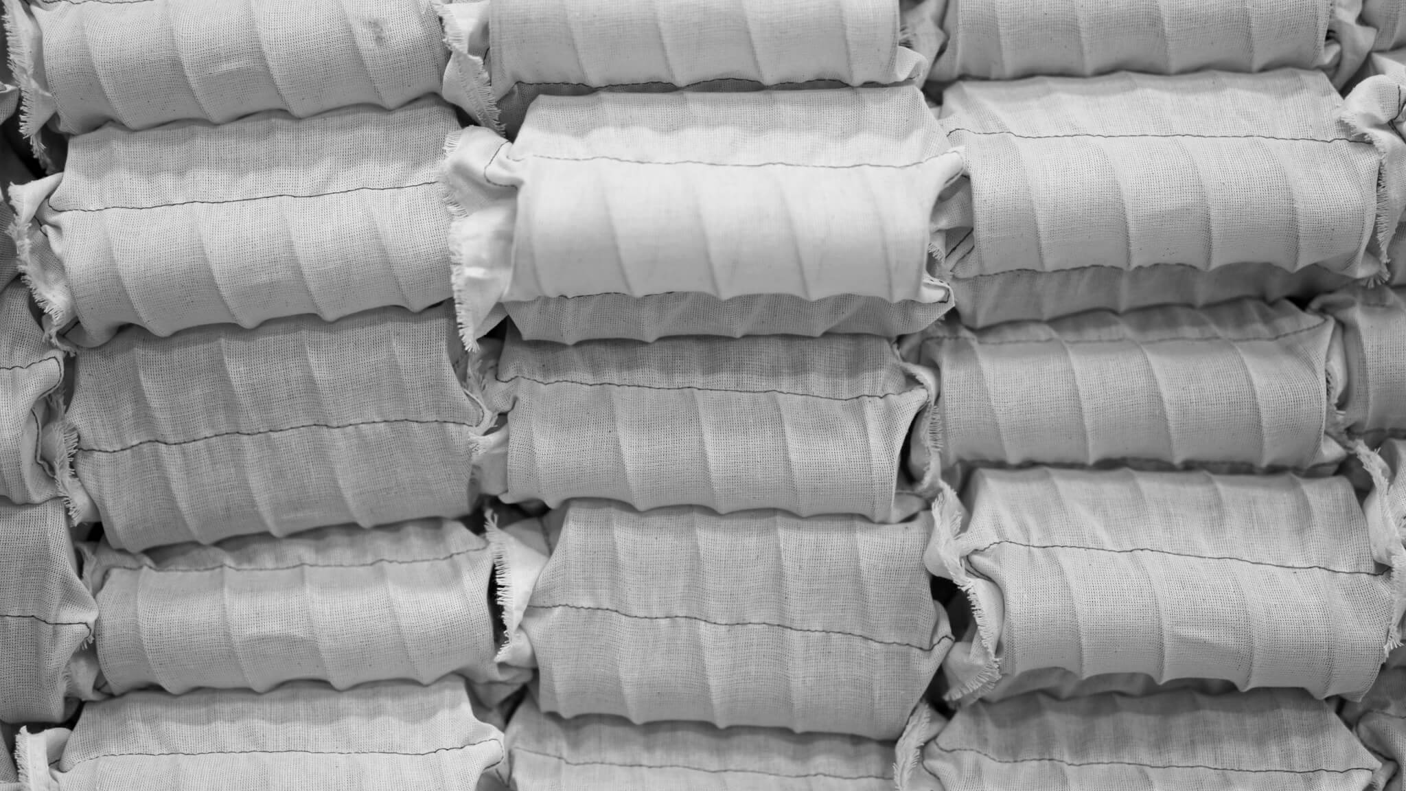 Closeup of pocket springs wrapped in natural calico in Savoir's Bedworks in Wales