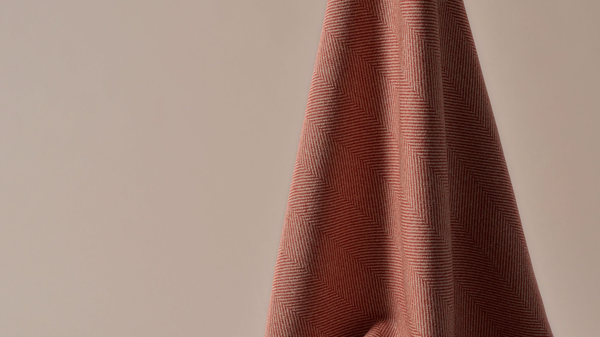 A close up image of one of our upholstery options, the intricate herringbone fabric showcasing a blend of rich red colour and soft cream tone.