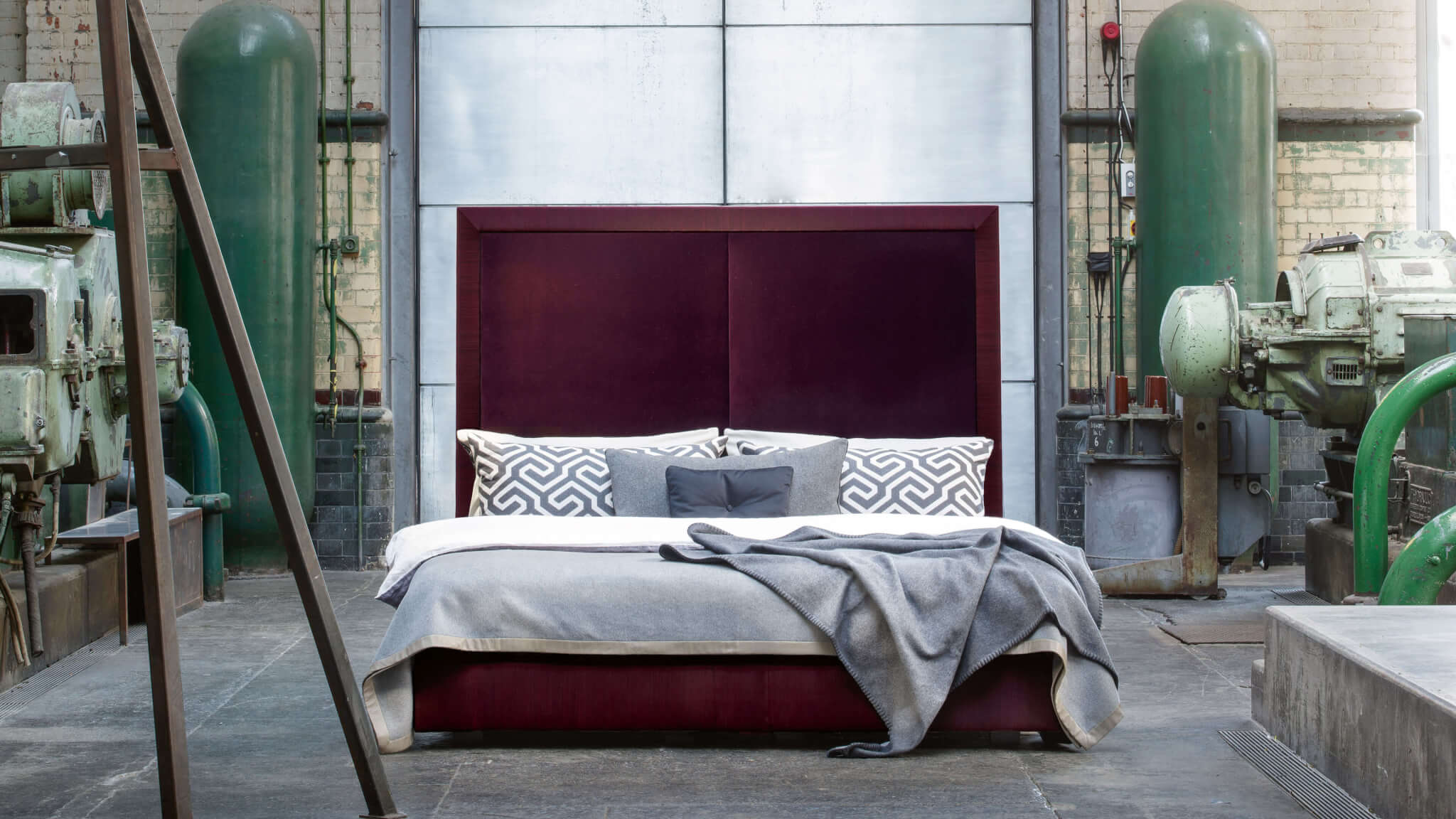 Savoir Max bed, upholstered in deep plum coloured velvet with horse hair fabric border