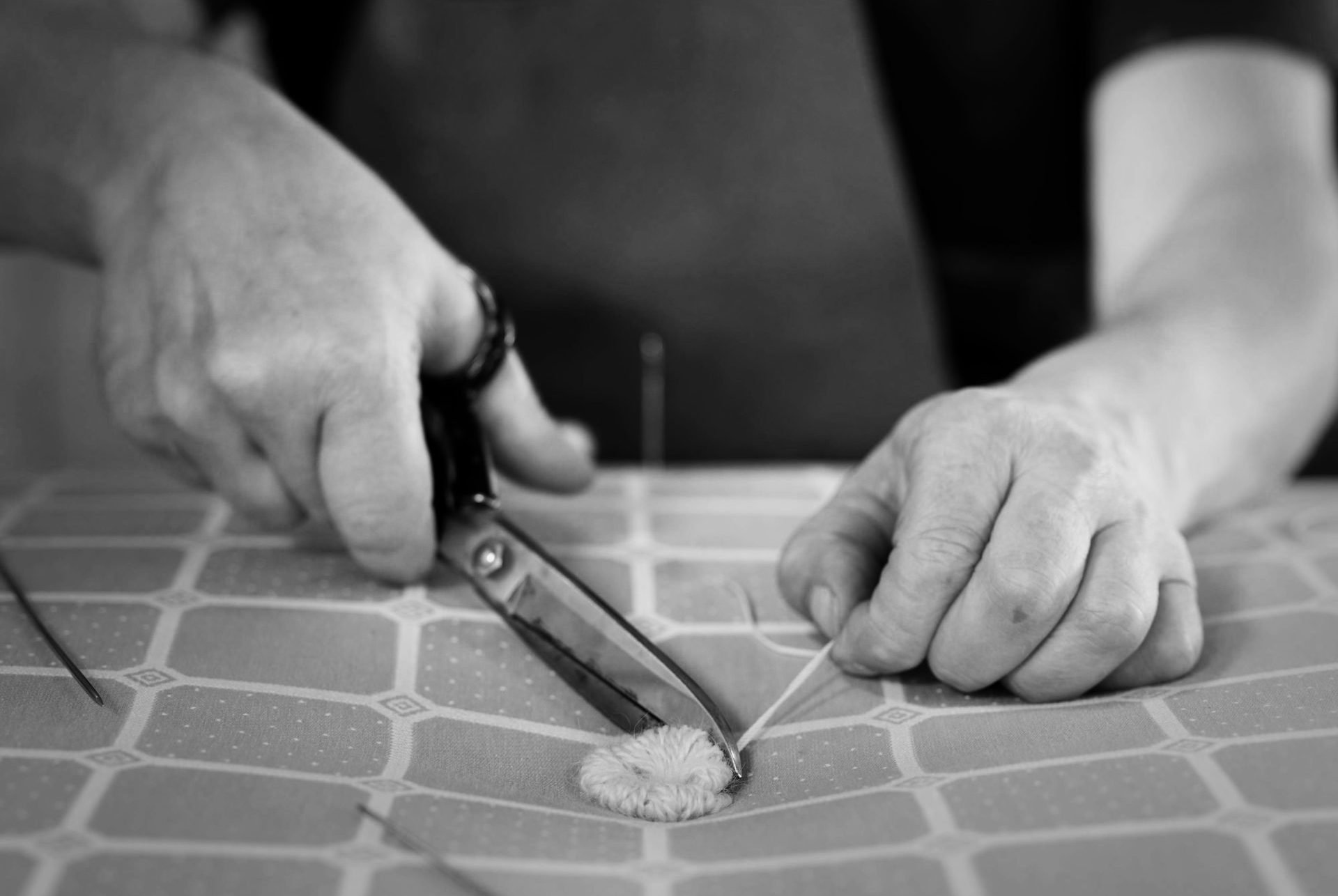 A Savoir craftsman hand tufting a mattress using wool tufts