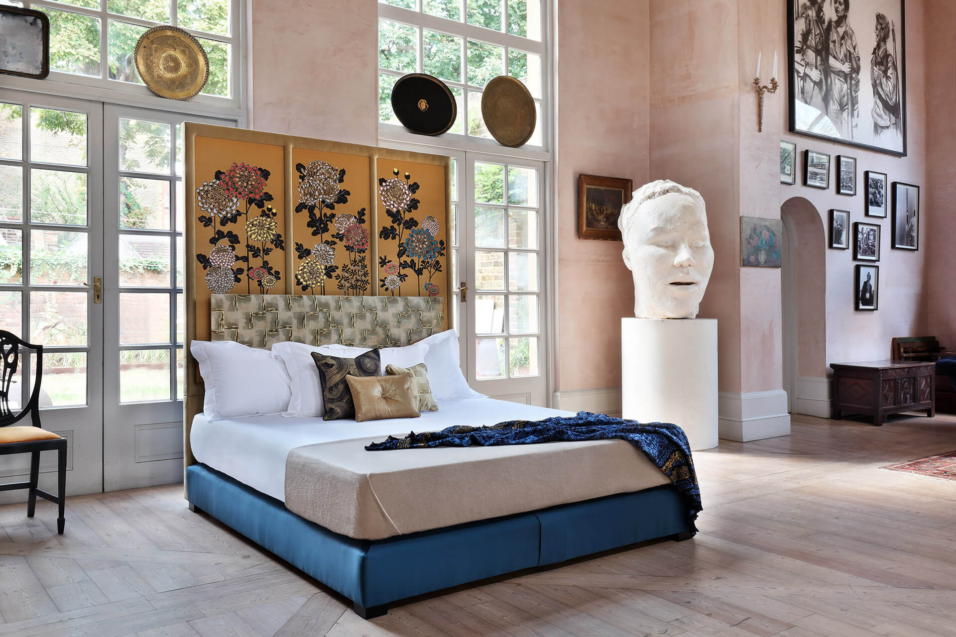 Savoir No3 bed with an opulent headboard featuring panels covered in Fromental's Kiku wallpaper design, finished with an upholstered border in a satin fabric