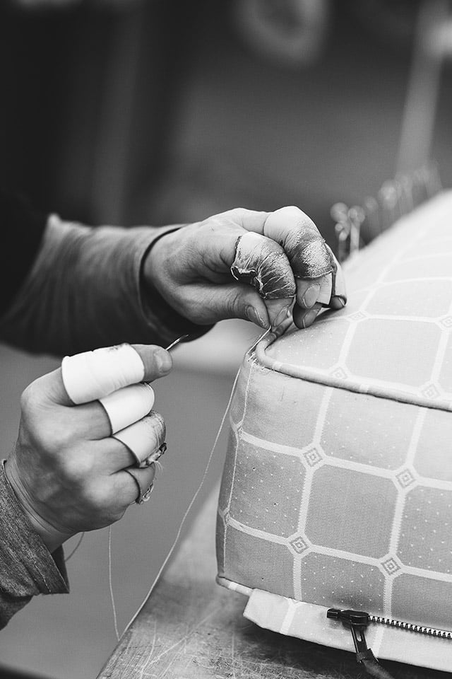 A craftsman hand stitches a Savoir mattress closed, allowing opulent amounts of horse hair to be inserted to elevate comfort and longevity