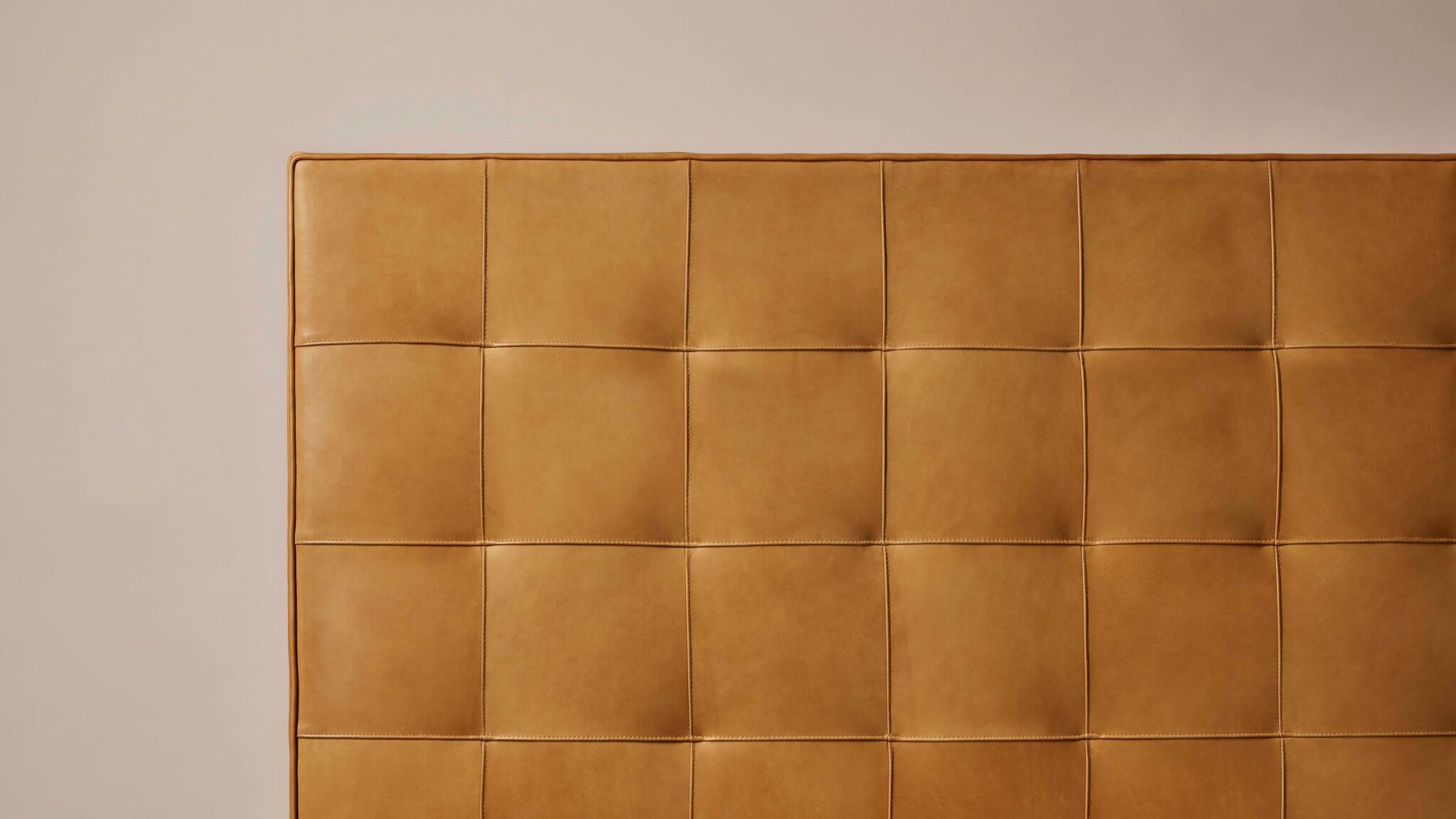 Closeup image of the Winston headboard upholstered in unique natural leather, showcasing the beautiful imperfections of a natural material