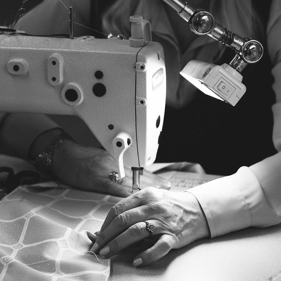 A seamstress sewing the Trellis ticking fabric which is used on every Savoir bed