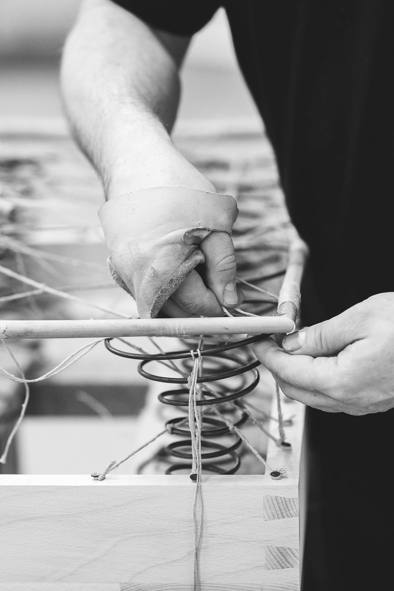 A craftsman making the cane edge on a No 1 box spring base