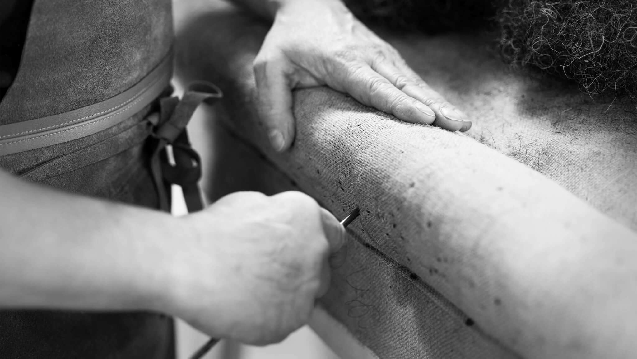 A craftsman making the hair roll edge on a No 2 box spring base