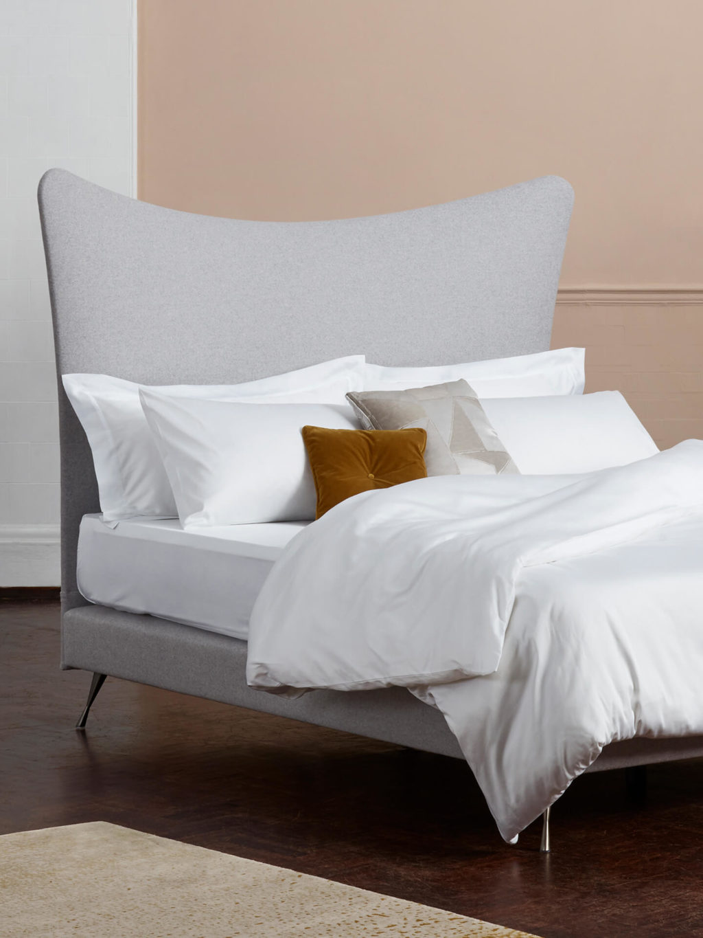 The Dream cotton sateen bed linen set photographed with a grey headboard