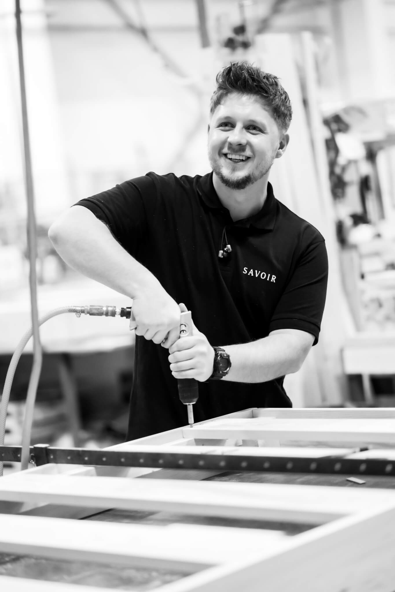 A craftsman in the Savoir Bedworks in Wales making a bed base