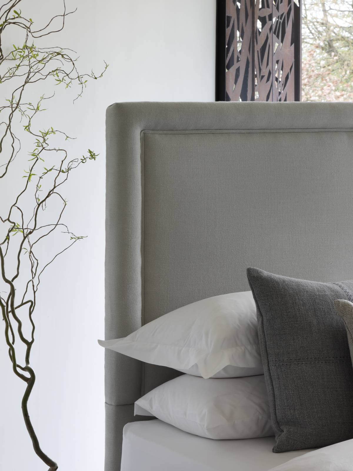 Close-up image of the headboard of our vegan bed, featuring a simple, modern shape and organic linen upholstery