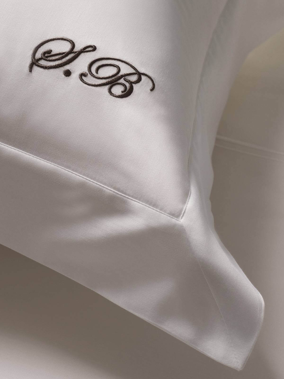 Image of embroidered monogramming on an Oxford style white sateen pillow.