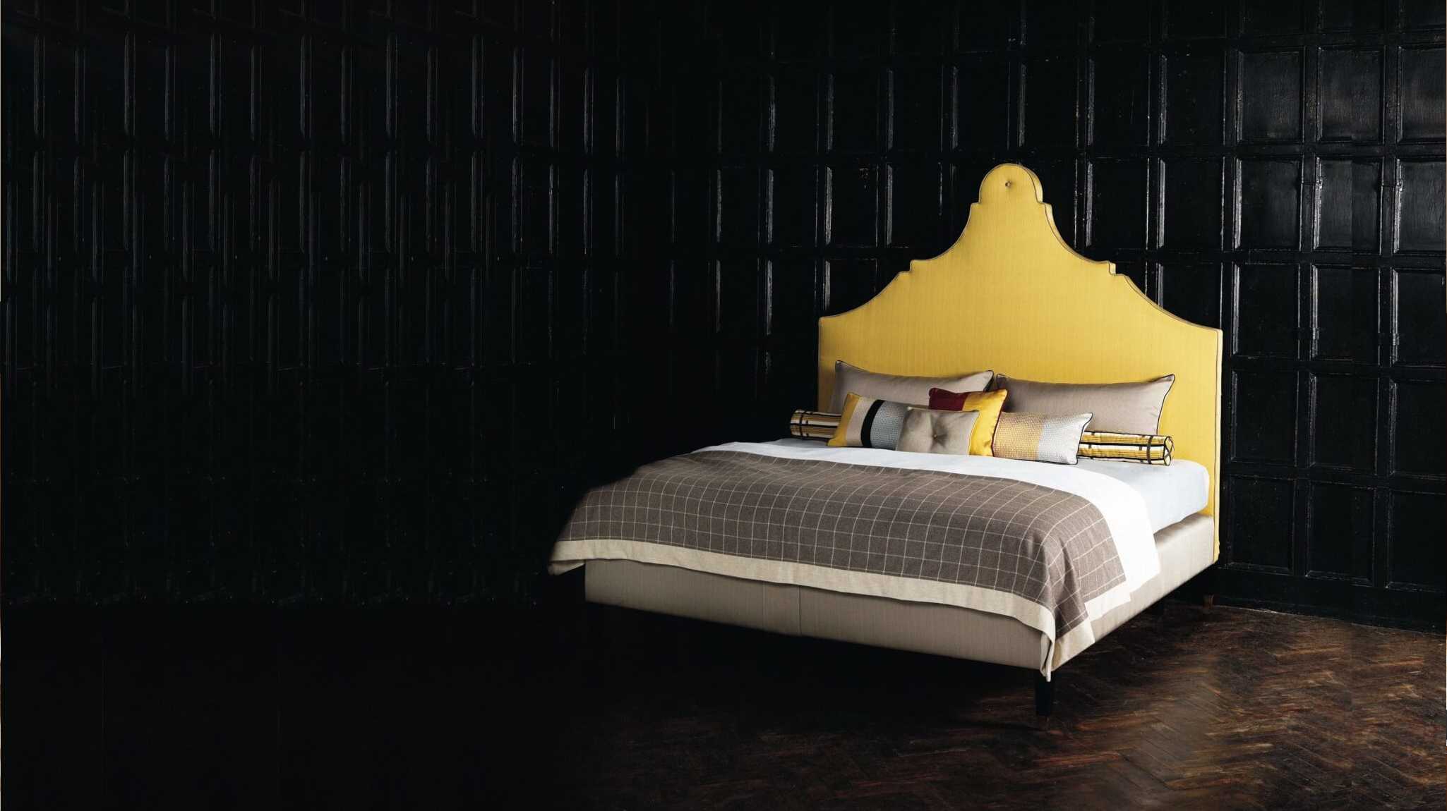 Bright yellow Claudia headboard photographed against a dark setting.