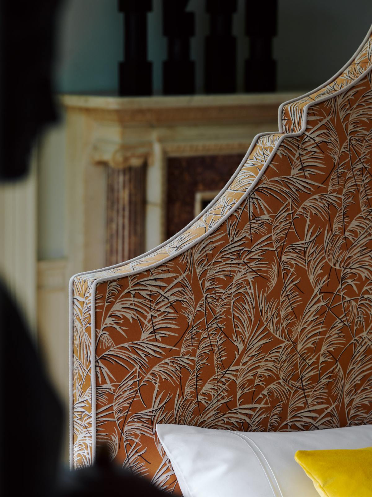 Detail of Claudia's headboard, upholstered in printed Lelievre 'Frozen leaves' fabric.