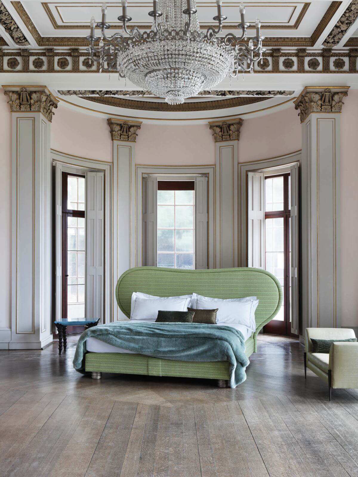 Image of the Louis bed, featuring a bright green tweed upholstery and a curved headboard, photographed in opulent, glamourous setting.