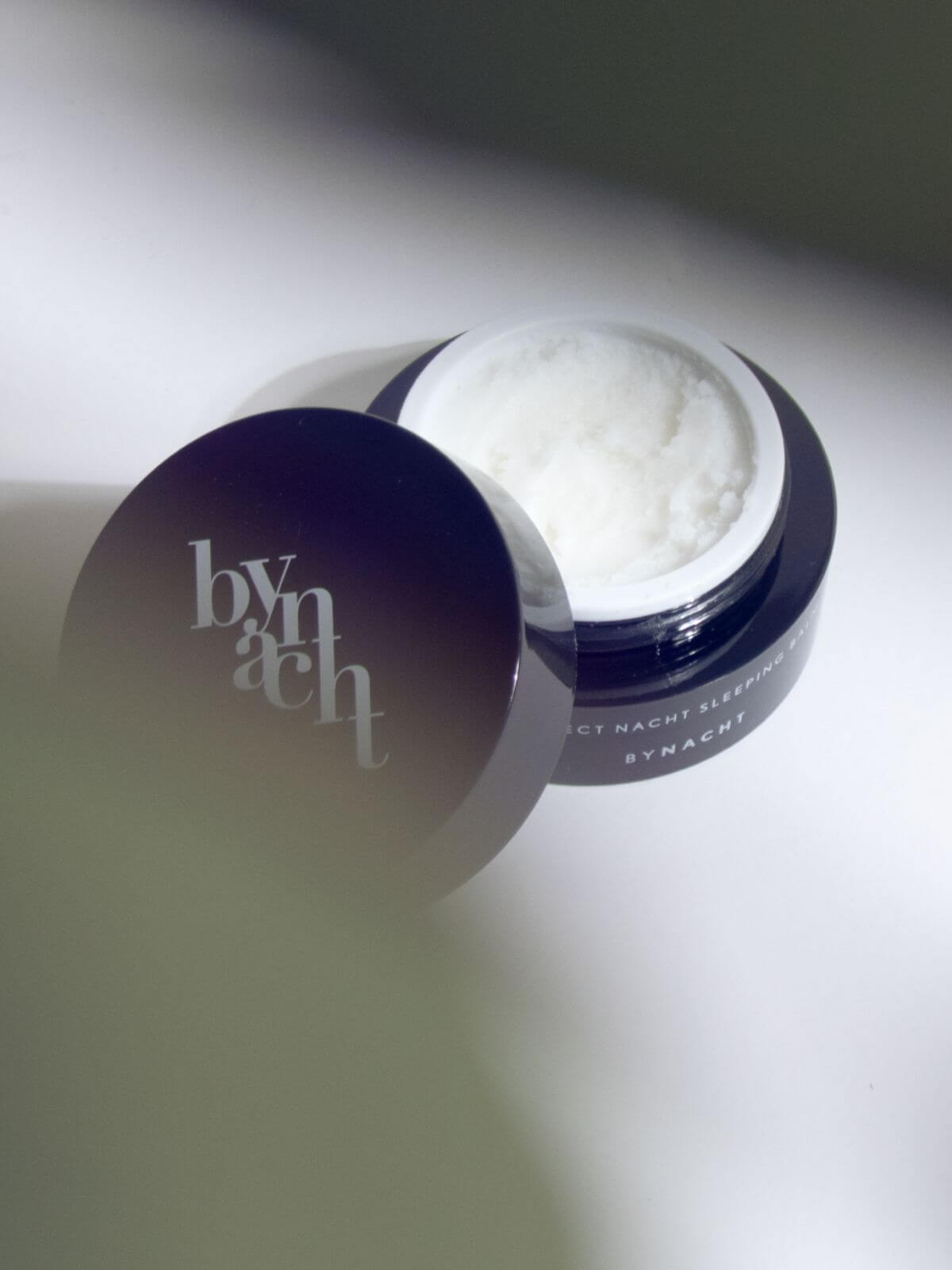 Image of BYNACHT's sleeping balm in an open container on a white table.