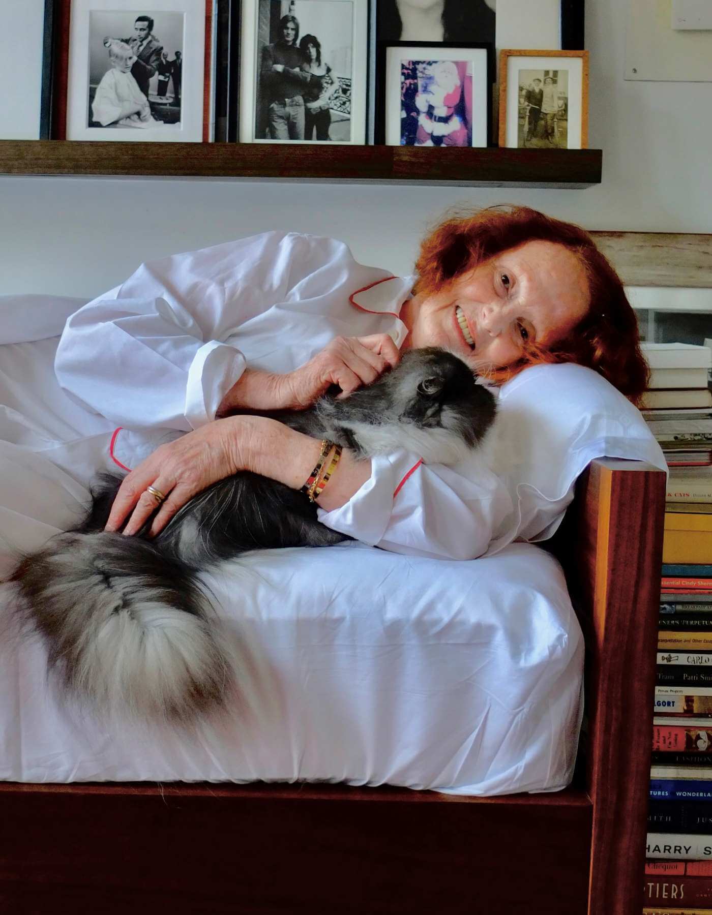 Grace Coddington wearing a nightgown resting on her Savoir mattress with her cat Jimmy