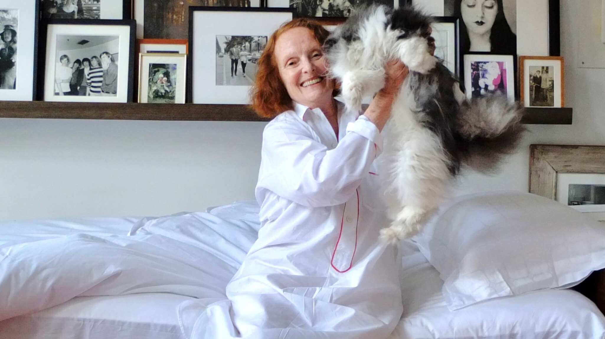 Grace Coddington wearing a nightgown resting on her Savoir mattress with her cat Jimmy