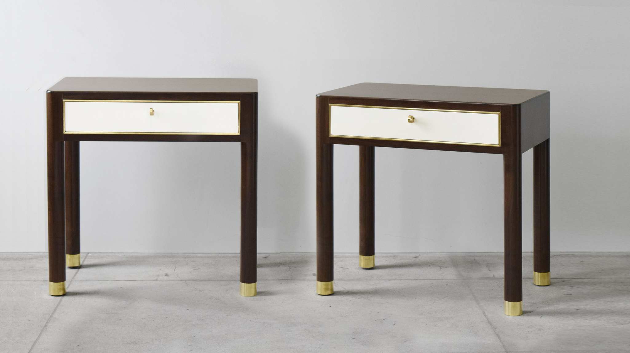 Two side tables created by Roman Thomas in dark walnut with white panels and golden details