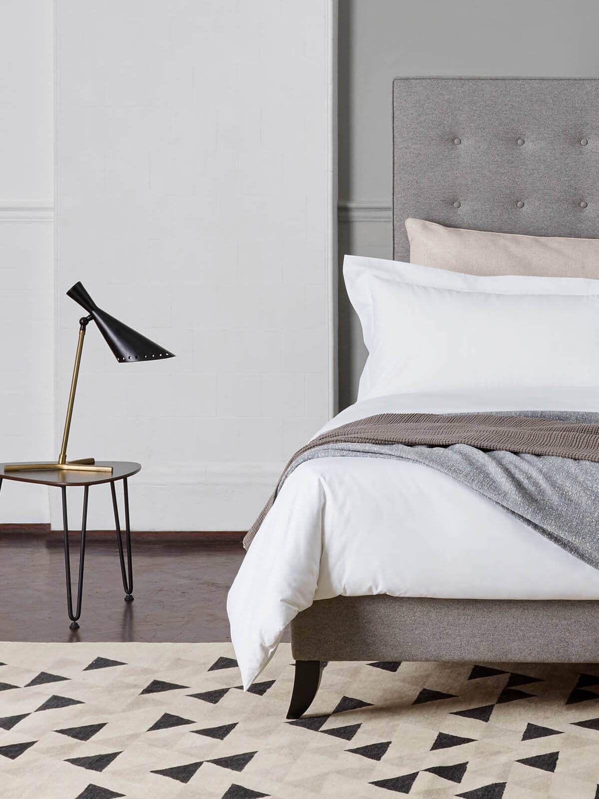 Image of Savoir Holly design, featuring calming grey linen upholstery, dressed in crisp, white bed linen.