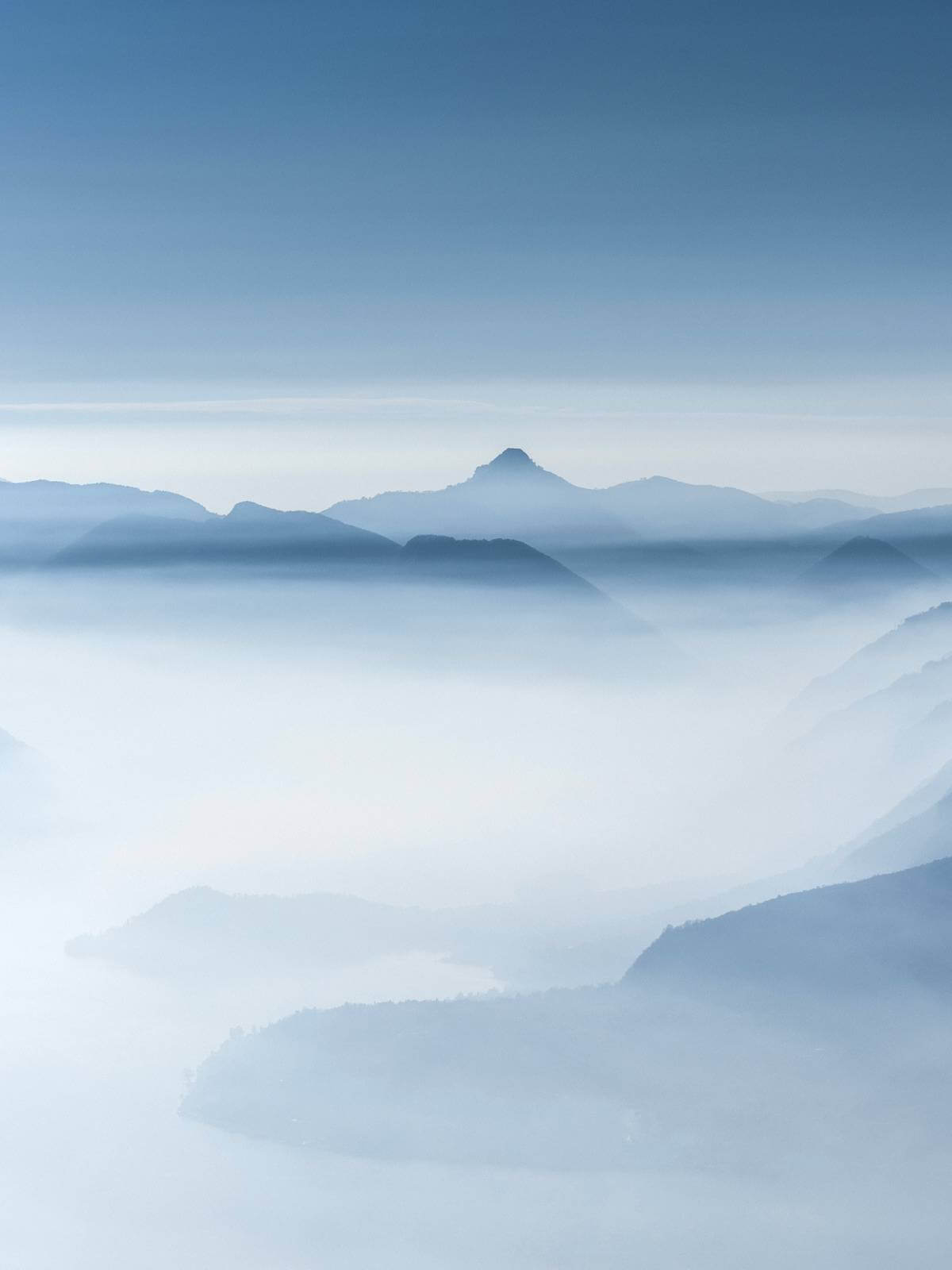 Image of misty clouds and mountain tops in all shades of blue