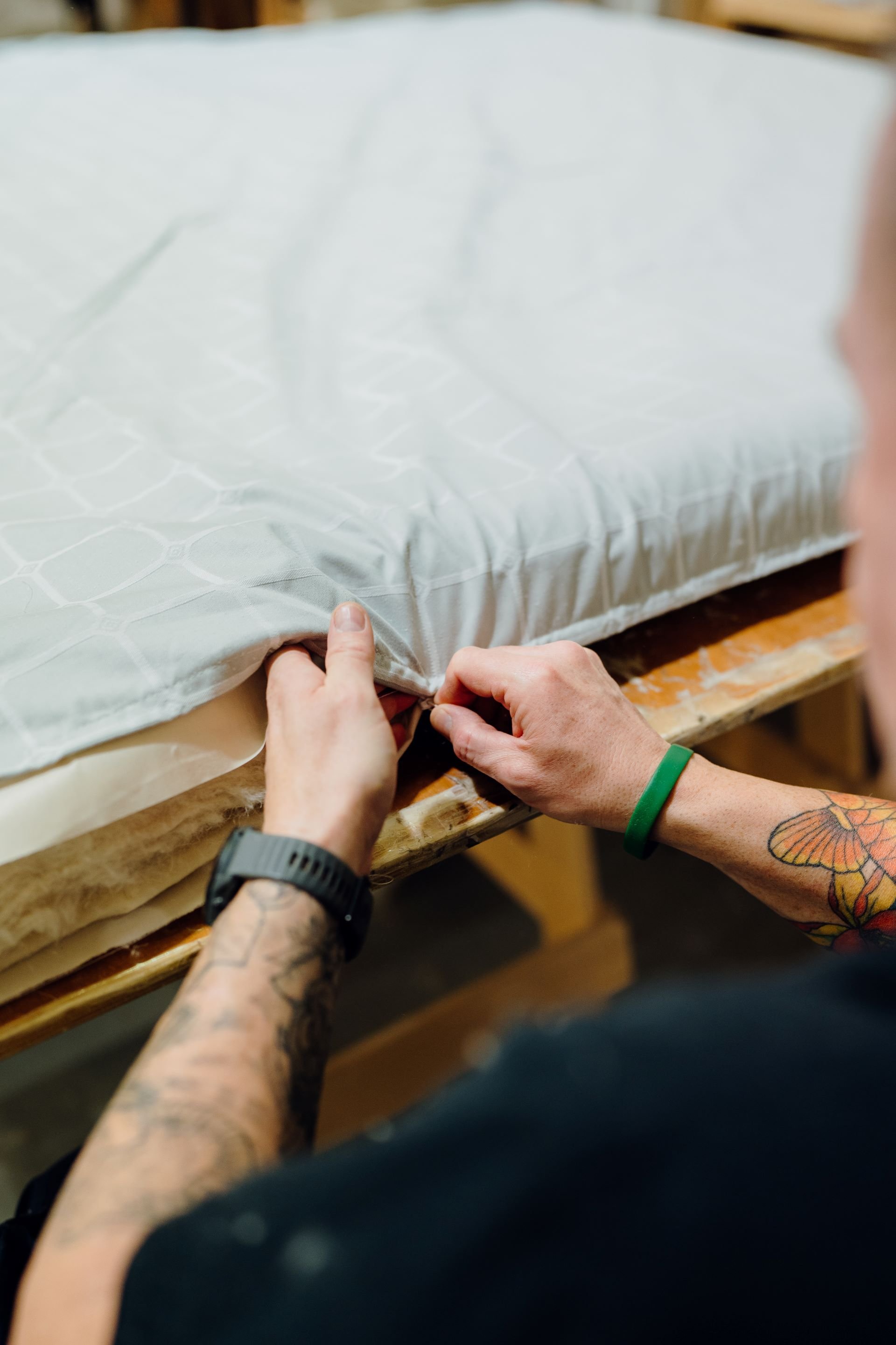 Image of a craftsman preparing a mattress with natural materials